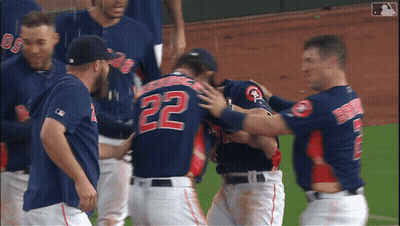 A Baseball Player With The Number 22 On His Back Is Hugged By His Teammates GIF