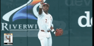 A Baseball Player With The Number 7 On His Jersey Stands In Front Of A Riverview Sign GIF
