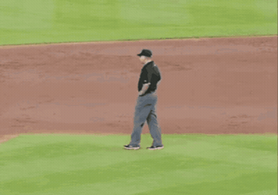 A Baseball Umpire Wearing A Ny Hat Stands On The Mound GIF