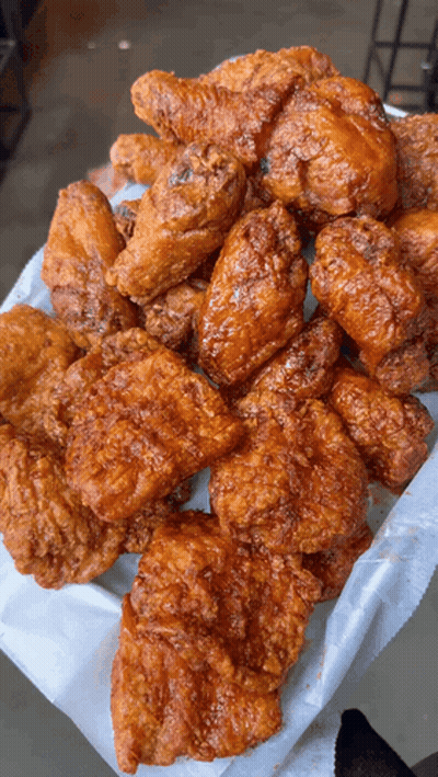 A Basket Of Fried Chicken Wings And Pieces Of Chicken GIF