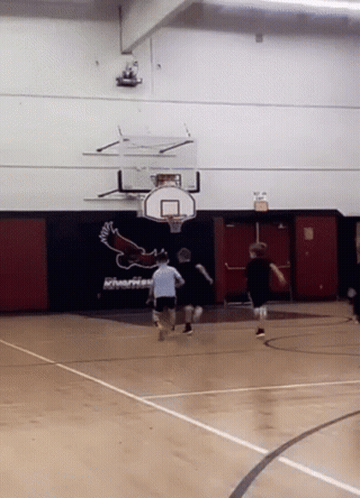 A Basketball Game Is Being Played In A Gym With A Riverhead Logo On The Wall GIF