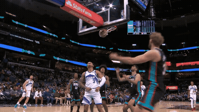 A Basketball Game Is Being Played In A Stadium With A State Farm Banner On The Hoop GIF