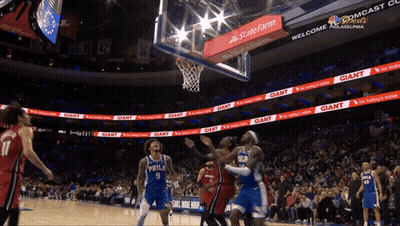 A Basketball Game Is Being Played In A Stadium With Giant Advertisements GIF