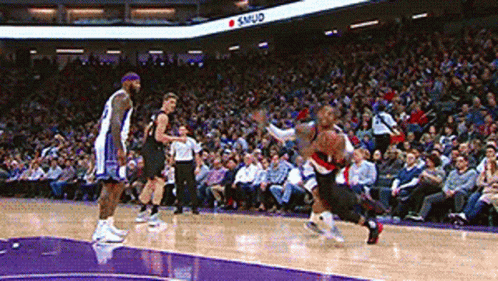 A Basketball Game Is Being Played In Front Of A Crowd And A Sign That Says Samud On It GIF