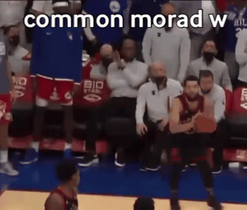 A Basketball Game Is Being Played In Front Of A Crowd Of People And A Basketball Player Is Jumping In The Air . GIF