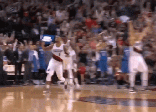 A Basketball Game Is Being Played In Front Of A Crowd That Is Cheering . GIF