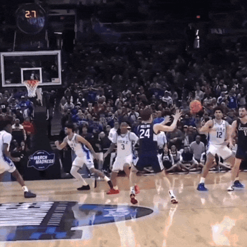 A Basketball Game Is Being Played In Front Of A Crowd With A Banner That Says Mercy Madness GIF
