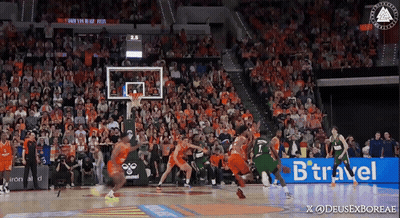 a basketball game is being played in front of a crowd with a btraveler ad in the corner