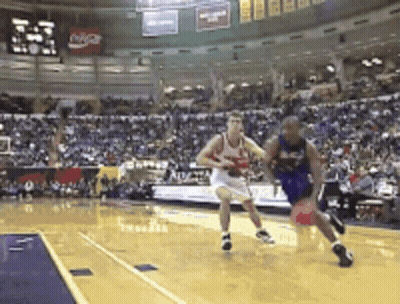 A Basketball Game Is Being Played In Front Of A Crowd With A Coca Cola Sign In The Background GIF