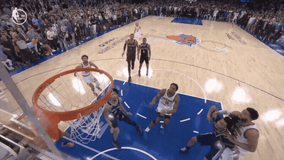 A Basketball Game Is Being Played In Front Of A Crowd With A New York Knicks Logo On The Court GIF