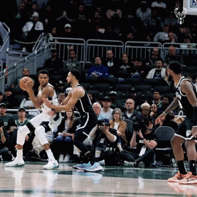 A Basketball Game Is Being Played In Front Of A Crowd With A Picture Of A Deer On The Scoreboard GIF