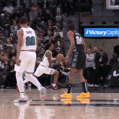 A Basketball Game Is Being Played In Front Of A Sign That Says Victory Capital GIF