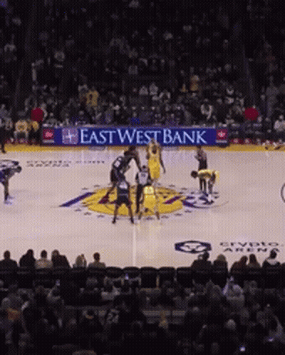 A Basketball Game Is Being Played In Front Of An East West Bank Ad GIF
