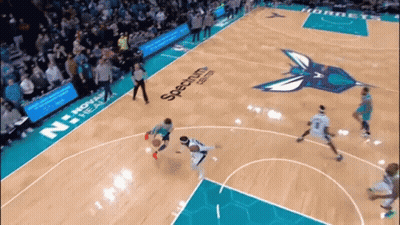 A Basketball Game Is Being Played On A Court That Has Spectrum Written On The Floor GIF