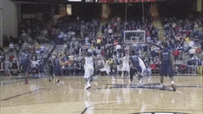 A Basketball Game Is Being Played On A Court With A Crowd Watching GIF