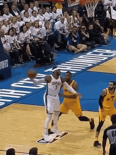 A Basketball Game Is Being Played On A Court With A Crowd Watching . GIF