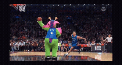 A Basketball Game Is Being Played With A Mascot Wearing A Purple And Blue Outfit With A Star On The Back GIF