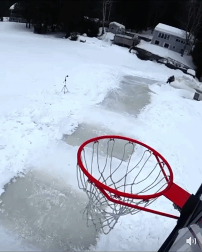 A Basketball Hoop In The Middle Of A Snowy Area GIF