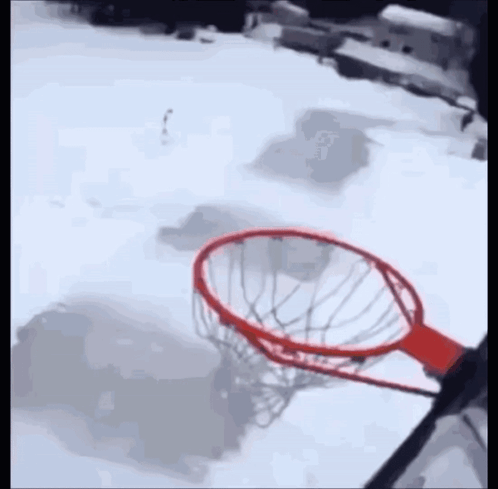 A Basketball Hoop Is In The Middle Of A Snowy Court GIF
