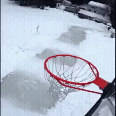 A Basketball Hoop Is Sitting In The Middle Of A Snow Covered Field GIF