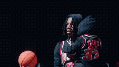 A Basketball Is Going Through A Basketball Hoop In A Gym . GIF