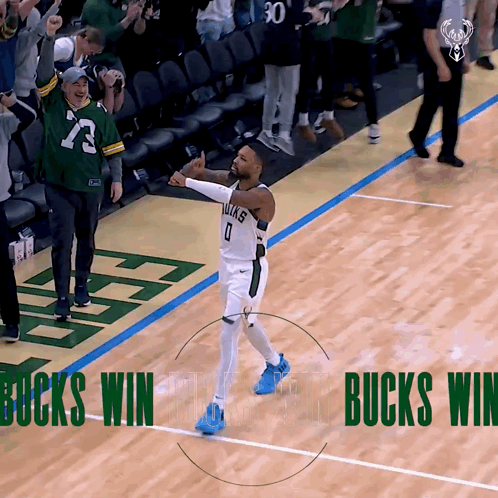 A Basketball Player Celebrates On The Court With The Words Bucks Win Behind Him GIF