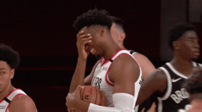 A Basketball Player Covering His Face While Holding The Ball GIF
