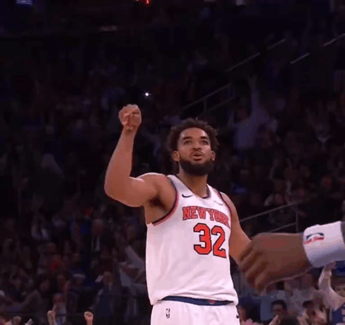 A Basketball Player For The New York Knicks Is Raising His Fist In The Air GIF