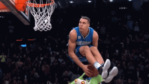 A Basketball Player For The Orlando Magic Jumps In The Air To Dunk The Ball GIF