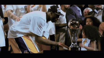 A Basketball Player Holds A Trophy In Front Of A Crowd GIF