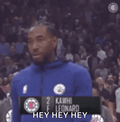 A Basketball Player In A Blue Jacket Is Standing In Front Of A Crowd . GIF