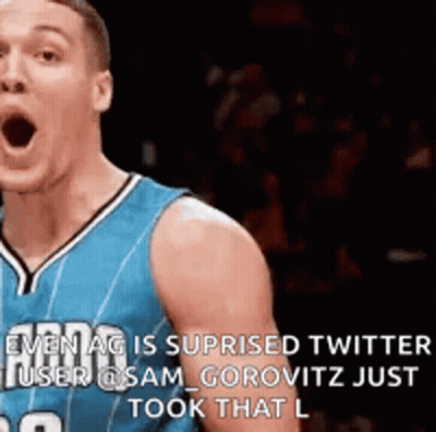 A Basketball Player In A Blue Jersey Is Making A Funny Face While Standing On The Court . GIF