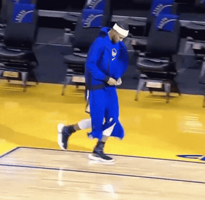 A Basketball Player In A Blue Uniform Is Walking On The Court . GIF