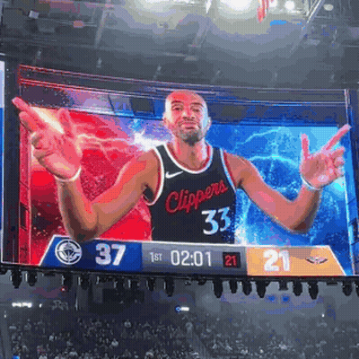 A Basketball Player In A Clippers Jersey Is On A Large Screen GIF