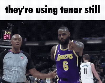 A Basketball Player In A Lakers Jersey Is Pointing At A Referee GIF