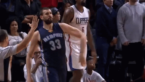 A Basketball Player In A Memphis Jersey Is Giving A High Five To Another Player . GIF