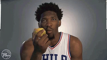 A Basketball Player In A Philadelphia 76Ers Uniform Is Eating A Lemon . GIF