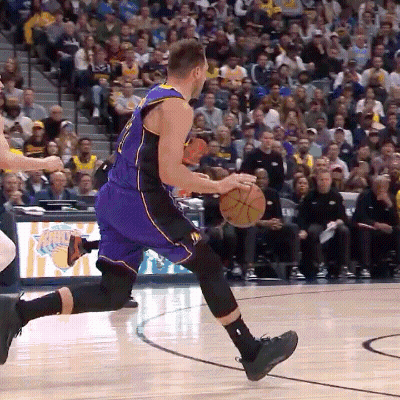 A Basketball Player In A Purple And Black Uniform Is Dribbling A Basketball GIF