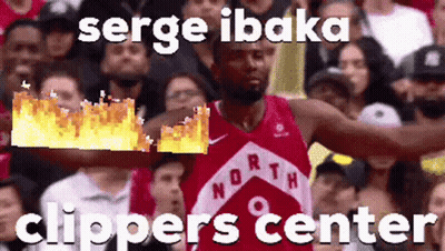 A Basketball Player In A Red Jersey Is Holding A Fireball In His Hand In Front Of A Crowd Of People . GIF