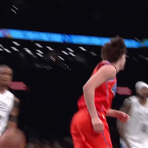A Basketball Player In A Red Jersey Is Running On The Court . GIF