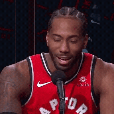 A Basketball Player In A Red Jersey Is Talking Into A Microphone . GIF