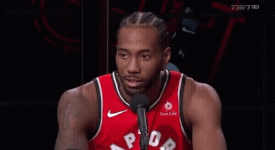 A Basketball Player In A Red Jersey Is Talking Into A Microphone And Smiling . GIF