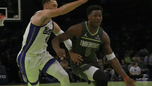 A Basketball Player In A Timberwolves Jersey Is Dribbling The Ball GIF
