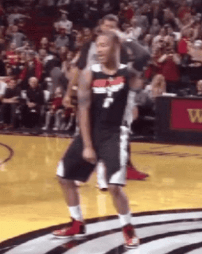 A Basketball Player Is Dancing On The Court In Front Of A Crowd During A Game . GIF