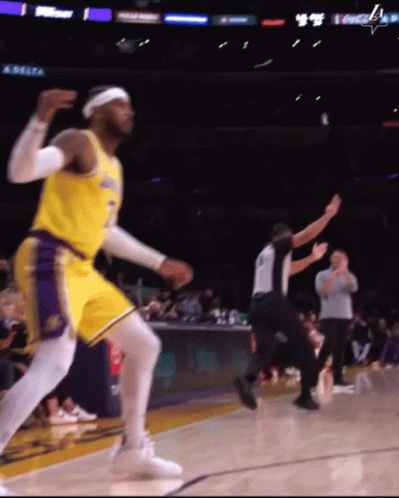 A Basketball Player Is Dancing On The Court While A Referee Looks On GIF