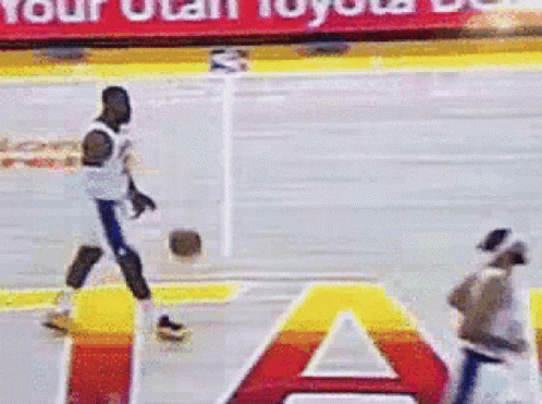 A Basketball Player Is Dribbling A Ball On A Court With A Toyota Banner In The Background GIF
