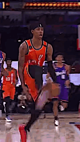 A Basketball Player Is Dribbling A Basketball On A Court While Other Players Watch . GIF