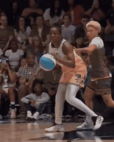 A Basketball Player Is Dribbling A Basketball While Another Player Tries To Stop Him . GIF