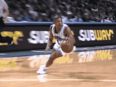 A Basketball Player Is Dribbling The Ball In Front Of A Subway Ad GIF