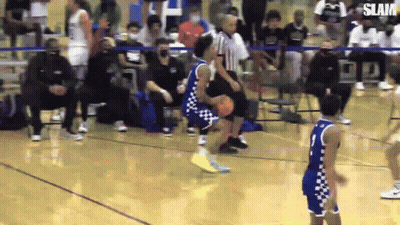 A Basketball Player Is Dribbling The Ball On A Court While Another Player Tries To Block Him . GIF
